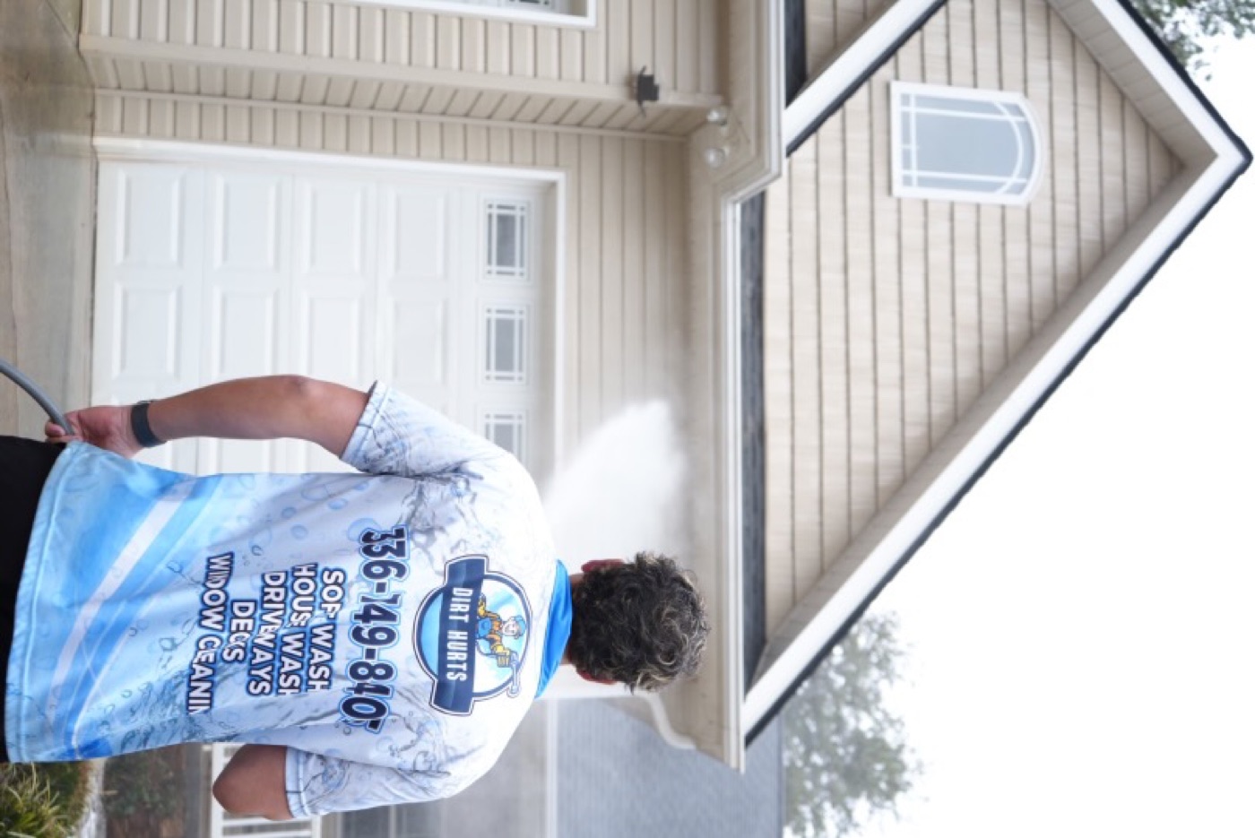 Landon from Dirt Hurts soft washing a home exterior